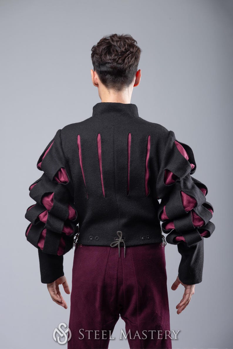 May include: A black jacket with burgundy accents and puffed sleeves. The jacket has a high collar and a lace-up back.