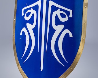 Op de afbeelding: Een blauw schild met een wit embleem en een goudkleurige rand. Het schild heeft een afgeronde bodem en is afgezet met kleine klinknagels. De tekst "STEEL MASTERY" staat onderaan.