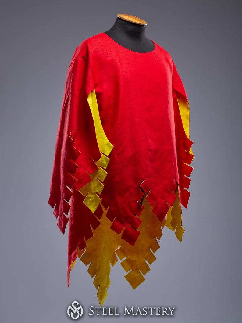 May include: A red tunic with yellow detailing and a flame-like pattern along the hem. The sleeves are lined with yellow. The garment is displayed on a black mannequin head.