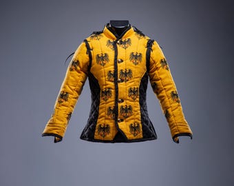 May include: A yellow and black quilted jacket with a high collar. The jacket features a repeating black eagle design and gold-colored buttons. The sleeves are long, and the jacket appears to be made of a padded material, possibly for protection.