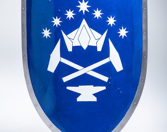 Op de afbeelding: Een blauw schild met een wit ontwerp. Het ontwerp bevat een kroon met zeven sterren, twee gekruiste hamers en een aambeeld.