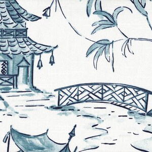 May include: A white fabric featuring a blue ink-style illustration of a multi-tiered pagoda building with hanging bells, a lattice-patterned arched bridge, and overhanging willow branches. The design uses varying shades of blue to create depth.