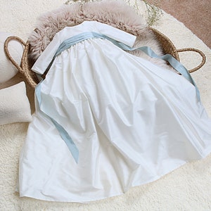 ivory silk christening gown with long sleeves and a matching long silk blue sash