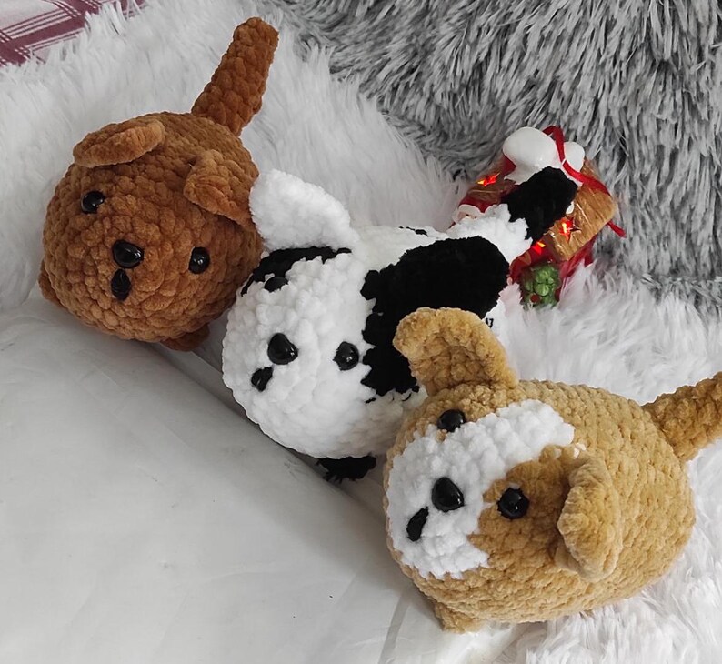 May include: Three crocheted plush dog toys. One is brown, one is black and white, and one is brown and white.