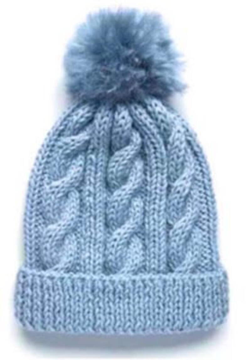 May include: A light blue knitted beanie with a fluffy pom pom on top. The beanie has a cable knit pattern.