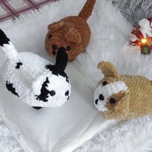 May include: Three crocheted plush dog toys. One is brown, one is black and white, and one is brown and white.