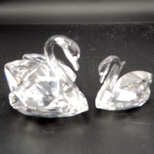 Un par de cisnes Swarovski, mamá y bebé, de 1" y 1 3/4" de alto.