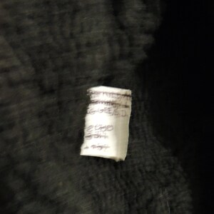 May include: A white tag with black handwritten text that reads "EST. 1957", "HANDMADE", "GINGERED", "2000", "300", "1 night".