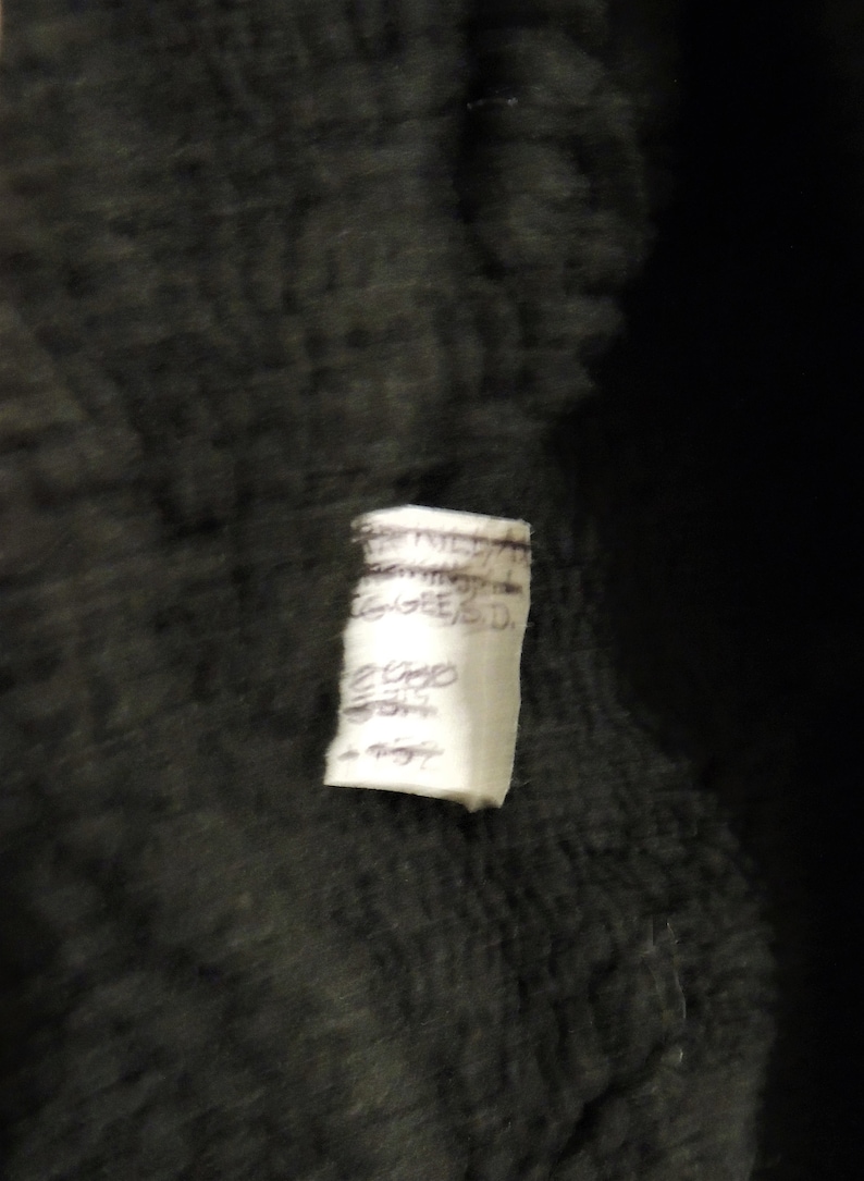 May include: A white tag with black handwritten text that reads "EST. 1957", "HANDMADE", "GINGERED", "2000", "300", "1 night".