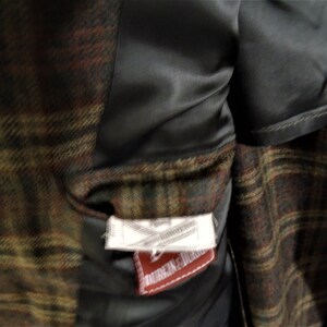 May include: A brown, green, and red plaid jacket with a black satin lining. The jacket has a label that reads "Made in England" and "Dunlop & Dunlop".