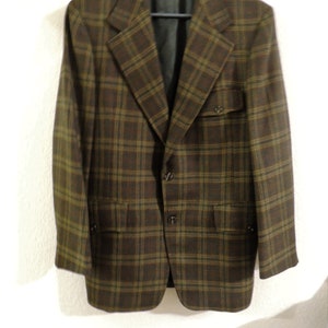 May include: A brown and green plaid blazer with a single button closure and two flap pockets.