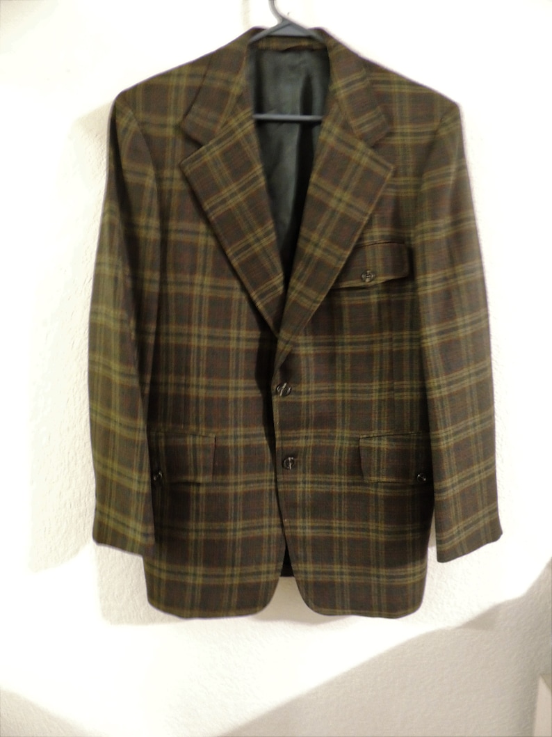 May include: A brown and green plaid blazer with a single button closure and two flap pockets.
