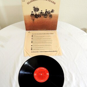 May include: A vintage vinyl record album by Blood, Sweat & Tears. The album cover features a sepia-toned image of the band and the text "BLOOD, SWEAT & TEARS". The record label is red with white text and the Columbia logo.