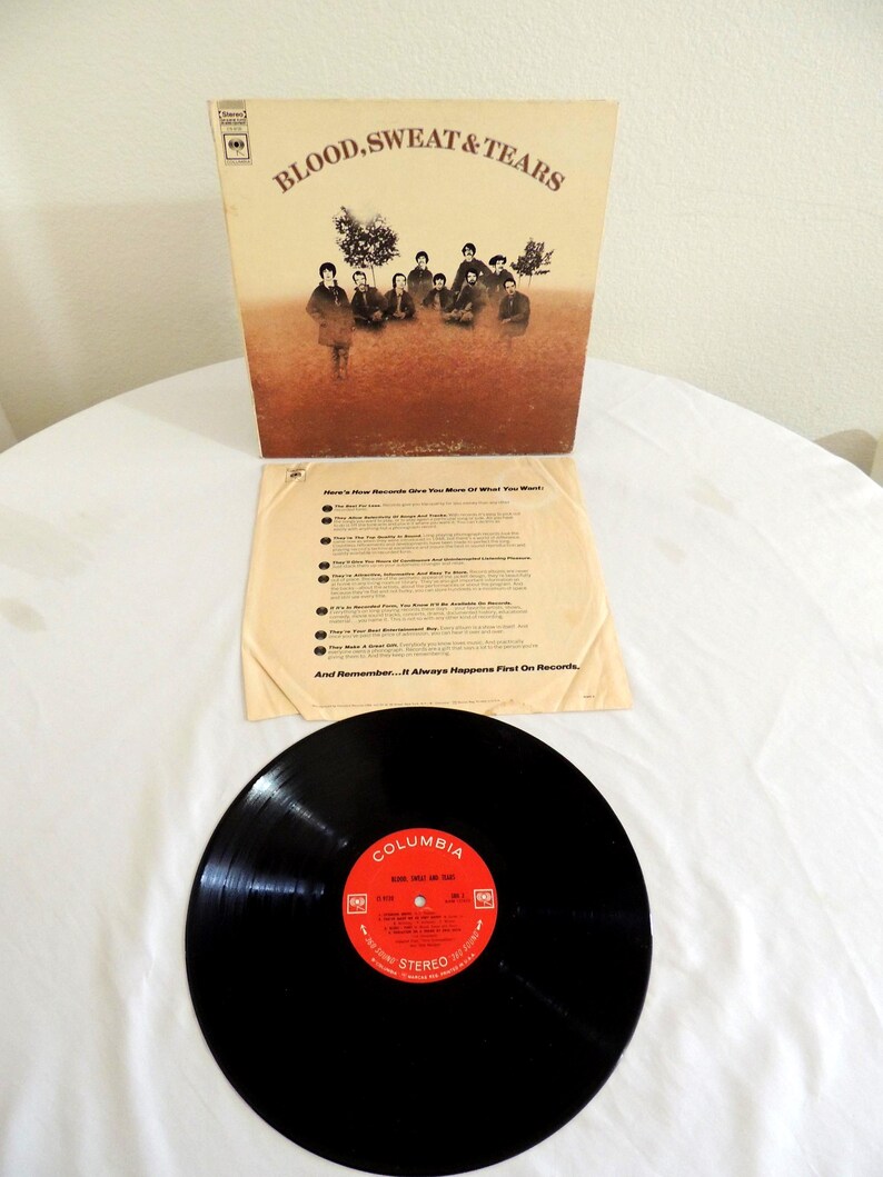 May include: A vintage vinyl record album by Blood, Sweat & Tears. The album cover features a sepia-toned image of the band and the text "BLOOD, SWEAT & TEARS". The record label is red with white text and the Columbia logo.