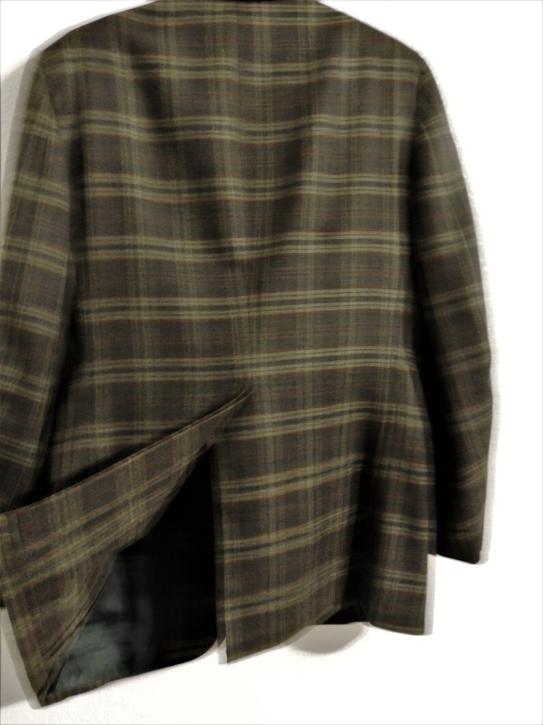 May include: A brown and green plaid blazer with a single vent in the back.