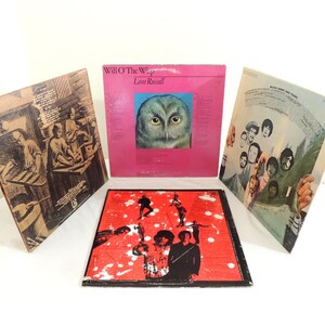 May include: Four vintage vinyl record album covers. One pink album cover features an owl's face, and the text "Will O' The Wisp" and "Leon Russell". Another album cover is red with black silhouettes. The other two album covers have illustrations.