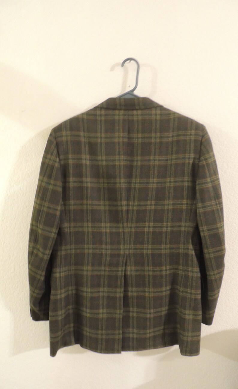 May include: A brown and green plaid blazer with a single vent in the back.