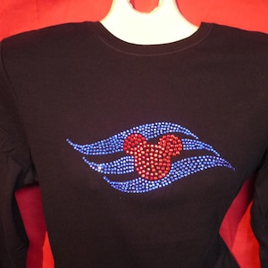 May include: Black long-sleeved shirt with a blue and red rhinestone design of a Mickey Mouse head and a wave.
