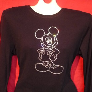 May include: Black long-sleeved shirt with a rhinestone Mickey Mouse design.