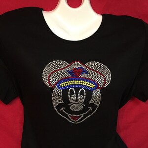 May include: Black t-shirt with a rhinestone design of Mickey Mouse wearing a sailor hat. The hat has red, white, blue, and yellow rhinestones.