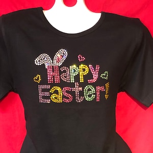 May include: Black t-shirt with a colorful rhinestone design that says "Happy Easter!" with bunny ears.