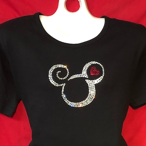 May include: Black t-shirt with a rhinestone Mickey Mouse head design. The Mickey Mouse head has a red heart in the middle.