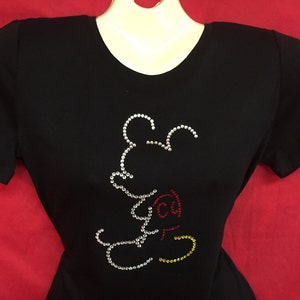 May include: Black t-shirt with a rhinestone Mickey Mouse design. The design features red, yellow, and white rhinestones.
