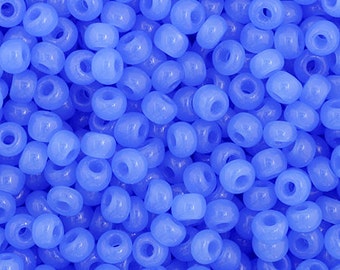 May include: A close-up image of a large quantity of small, round, light blue beads. The beads have a hole in the center and are made of a translucent material.