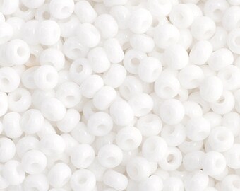May include: A close-up view of a large quantity of small, white, round seed beads. The beads are opaque and have a smooth, glossy finish.