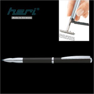 Op de afbeelding: Een zwarte pen met zilveren accenten en een blauwe inktpunt. De pen heeft een strak ontwerp en een zilveren clip. De afbeelding toont ook een stempel met de tekst "Made in Germany" en een kleine stempel met tekst.