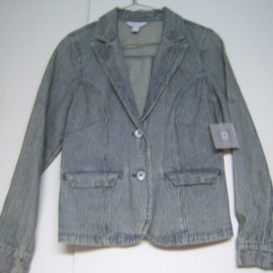 May include: A blue and white striped blazer with two front pockets and two buttons. The jacket is hanging on a hanger. A tag is attached to the sleeve.