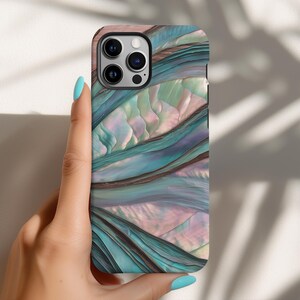 May include: A smartphone case with a swirling, abstract design in shades of teal, purple, and pink. The case has a glossy finish and a camera cutout. The case is held by a hand with blue nail polish.