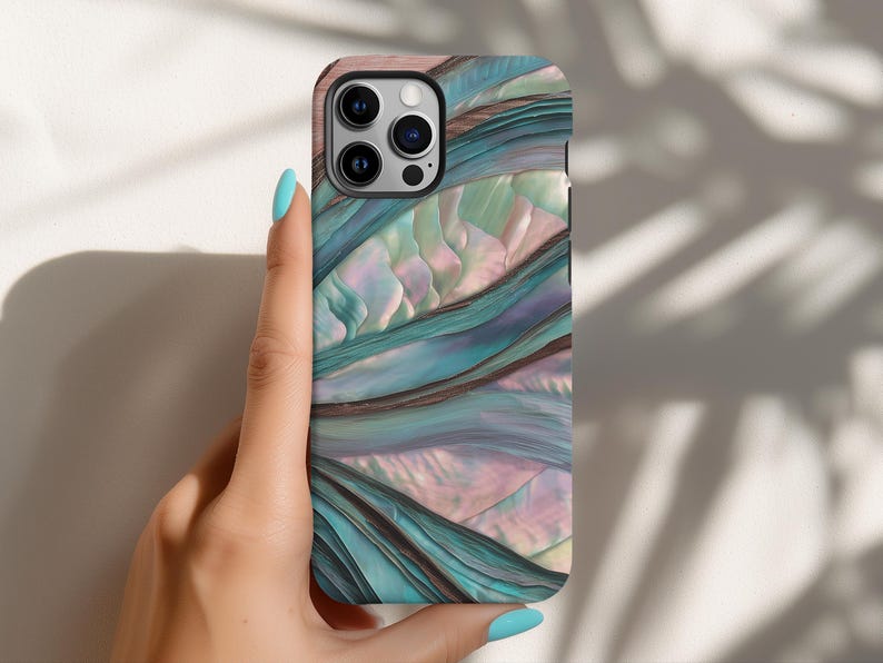May include: A smartphone case with a swirling, abstract design in shades of teal, purple, and pink. The case has a glossy finish and a camera cutout. The case is held by a hand with blue nail polish.