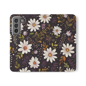 May include: A black phone case with a white daisy floral pattern. The case has a camera cutout on the back.