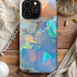 以下が含まれることがあります： カラフルなオパールデザインの携帯電話ケース。ケースは硬質プラスチック製で、背面は透明です。オパールデザインは虹色で、青、緑、ピンク、オレンジの色合いが特徴です。