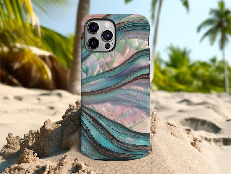 May include: A smartphone case with a flowing, abstract design in shades of teal, brown, and pink. The case has a glossy finish and a multi-camera lens cutout. The background shows a sandy beach and palm trees.