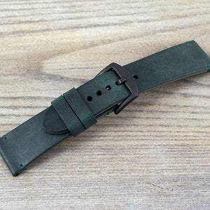 Op de afbeelding: Een donkergroen leren horlogebandje met een zwarte gesp. Het bandje heeft een gestikte rand en is ontworpen voor een horloge met een lugbreedte van 20 mm.