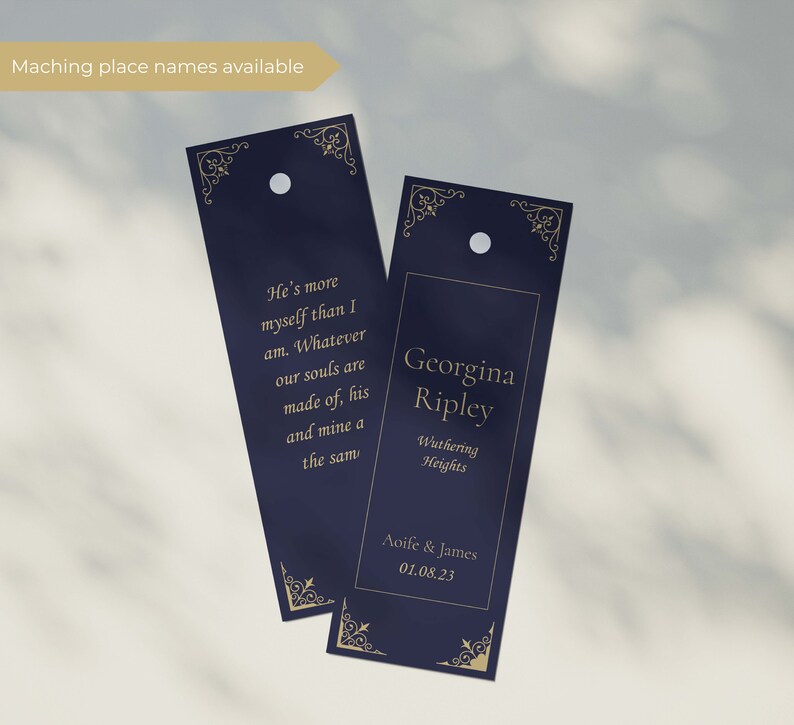 May include: Two navy blue wedding place cards with gold lettering. The left card has a quote: "He's more myself than I am. Whatever our souls are made of, his and mine a the sam". The right card has the name "Georgina Ripley", the location "Wuthering Heights", and the date "Aoife & James 01.08.23".