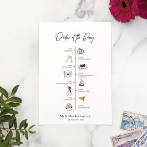 May include: A white wedding order of the day timeline with black text and illustrations. The timeline includes the ceremony, welcome drinks, photographs, wedding breakfast and speeches, cutting of the cake, the first dance, pizza van, and last carriages. The text at the bottom reads "Mr & Mrs Rotherford 5th September 2021".