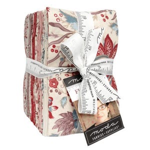 May include: A stack of fabric squares tied with a white ribbon printed with a ruler design. The fabric features floral patterns in red, blue, and cream colors. A tag with the "moda FABRICS + SUPPLIES" logo is attached.