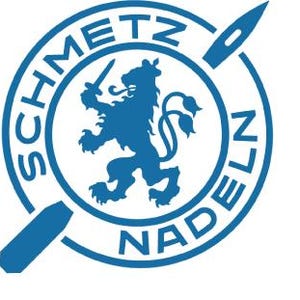 May include: A blue circular logo with the text "SCHMETZ NADELN" around the edge. Inside the circle is a blue lion with a sword in its paw and a stylized needle.