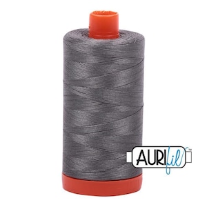 May include: A spool of gray thread with an orange top and base. The thread is tightly wound, and the spool has the Aurifil logo on the side. This thread is likely used for sewing, quilting, or embroidery projects.
