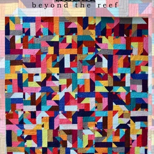 May include: A colorful quilt with a geometric pattern of squares and triangles in shades of red, orange, yellow, green, blue, purple, pink, brown, and gray. The quilt is titled "Beyond the Reef:  Morphois".