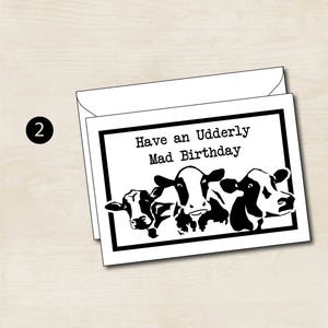 May include: A black and white greeting card with a humorous birthday message that says "Have an Udderly Mad Birthday" and features a cartoon image of three cows.