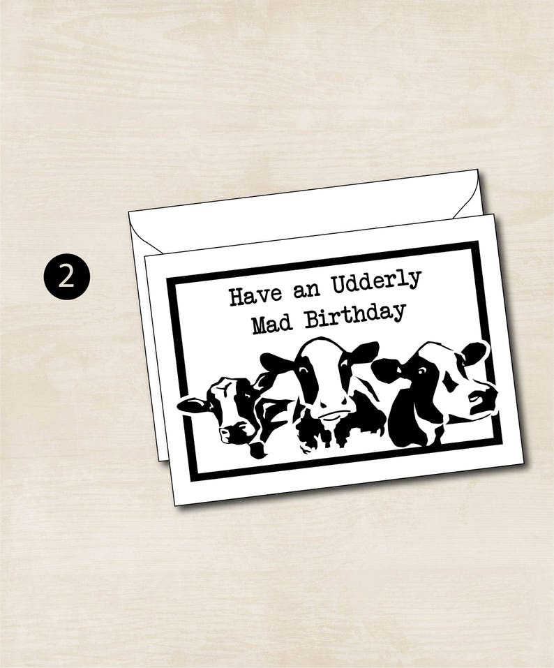 May include: A black and white greeting card with a humorous birthday message that says "Have an Udderly Mad Birthday" and features a cartoon image of three cows.