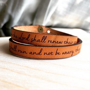 May include: A brown leather wrap bracelet with the inscription "They that wait on the Lord shall renew their strength; they shall run and not be weary, they shall walk and not faint."