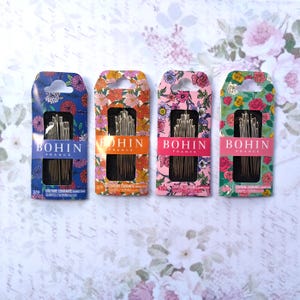 May include: Four rectangular packages of Bohin France sewing needles, each featuring a unique floral pattern in blue, orange, pink, and green. Each package displays the brand name, the text Couture Courante, and the size 3/9 on the front.
