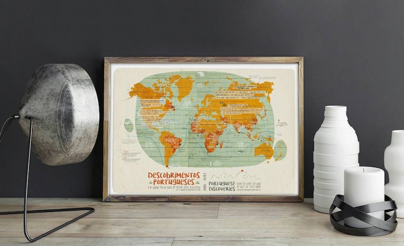 May include: A framed world map with a vintage style design. The map is coloured in shades of yellow, green, and blue. The title of the map is "Descobrimentos Portugueses" which translates to "Portuguese Discoveries".
