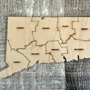 May include: A wooden map of Connecticut, divided into eight counties: Litchfield, Hartford, Tolland, Windham, Middlesex, New Haven, Fairfield, and New London.