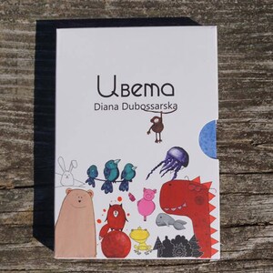 May include: A white book with a blue border and the title "Ubema Diana Dubossarska" on the front cover. The cover features colorful illustrations of animals, including a bear, a rabbit, birds, a pig, a dinosaur, a fish, and a frog.